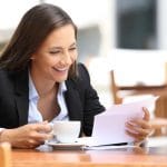 85244956 – single happy businesswoman reading a letter sitting in a coffee shop