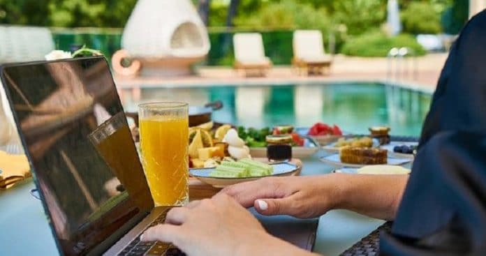 Sitting by pool with laptop